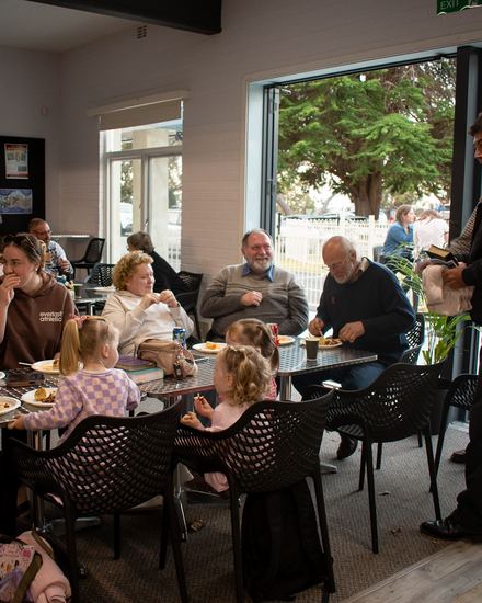 Families and friends sharing dinner together at tables in the Calvary cafe after the afternoon gathering