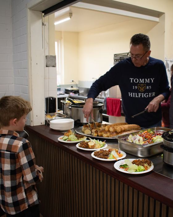 Calvary people serving up dinner after the gathering