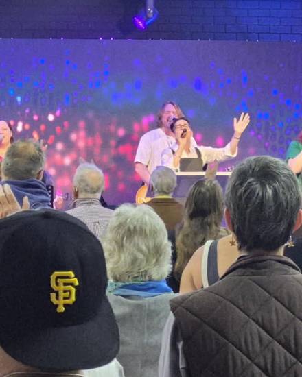 The worship band on stage with the congregation singing along