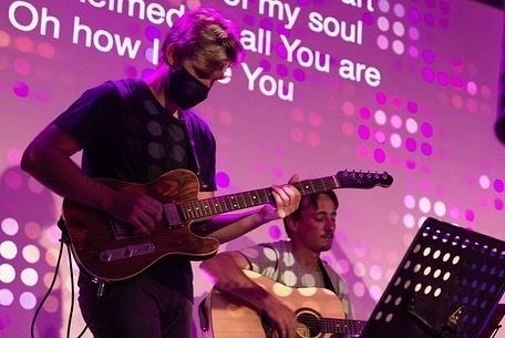 A guitarist leading worship