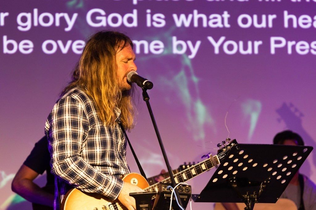 A guitarist leading worship